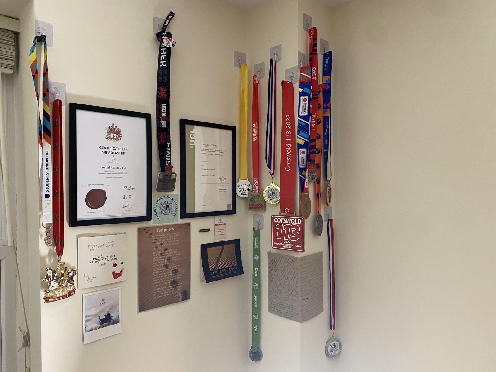 Wall of medals, certificates, and keepsakes from races and milestones